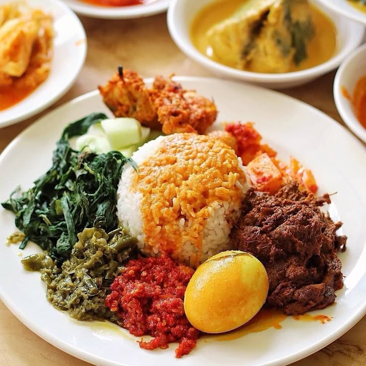 A plate of authentic Nasi Padang with rice, beef rendang, sayur, sambal, and telur balado
